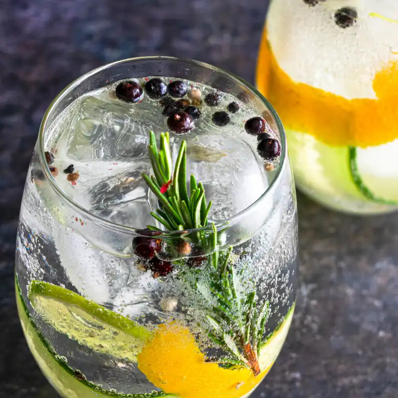 Gin Tonic mit Eis, Wachholderbeeren und Rosmarin